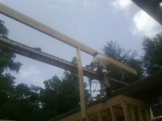 Carpenter setting a ridge beam over a new addition frame — Ice Dam Removal by Roofing Brothers in Fernwood