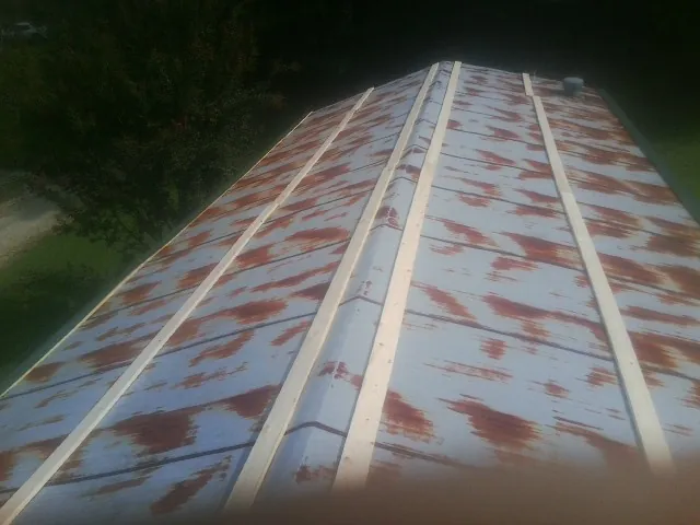Rusted metal roof panels with new wood purlins before replacement — Storm Damage Roof Repair in Fernwood by Roofing Brothers